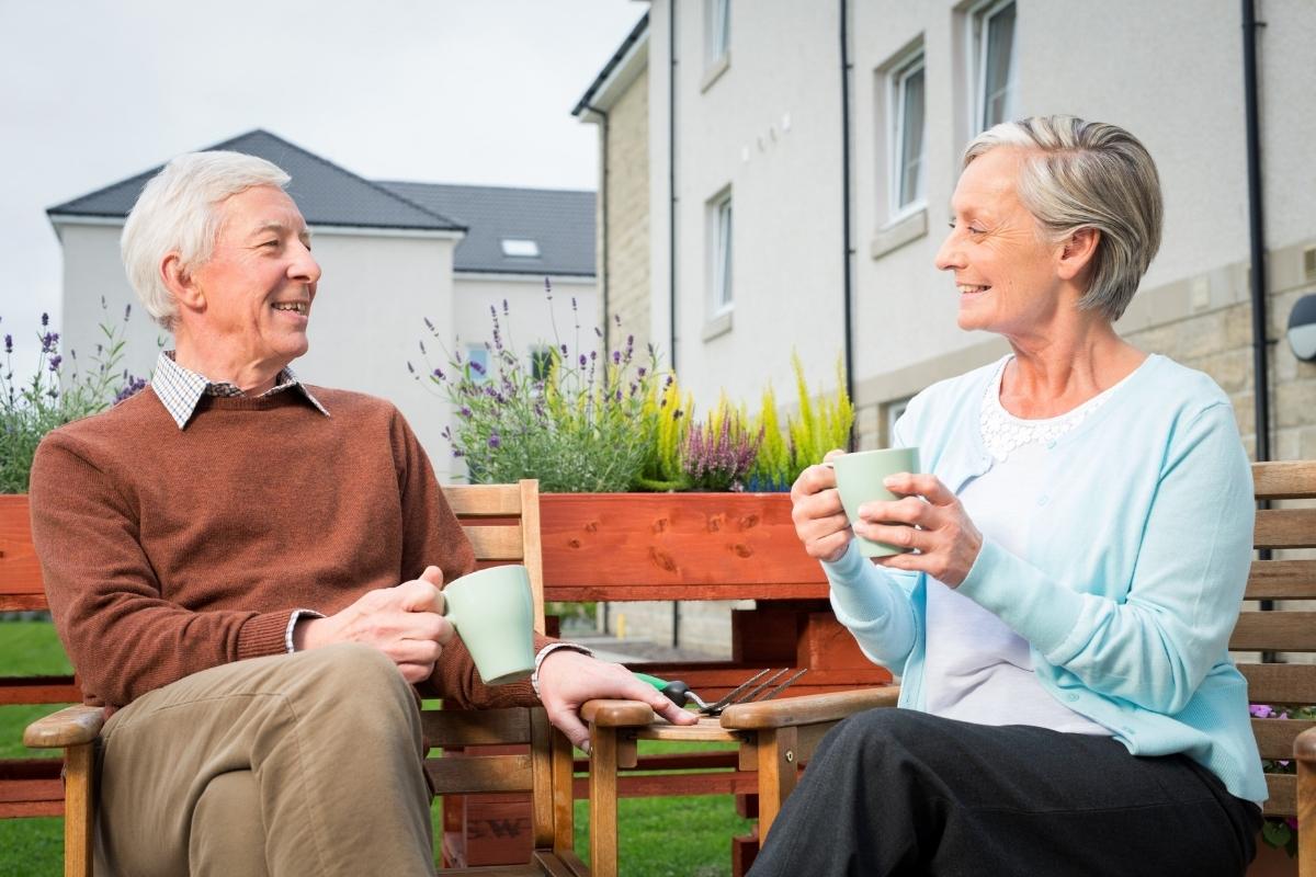 elderly people enjoying sitting outdoors in good weather